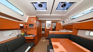 A compact interior with a central table, cushioned seating, control panels, and overhead windows. - Sun-Kissed Sailing Adventure in Zadar, Croatia (Zadar)
