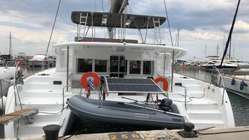Un bateau était amarré dans une marina. Il avait une cabine blanche, un petit canot pneumatique et le chiffre « 256 » était peint sur le quai.
