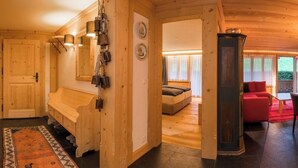 Ein Holzinnenraum mit einer Bank, einem Bett und einem roten Sofa.
