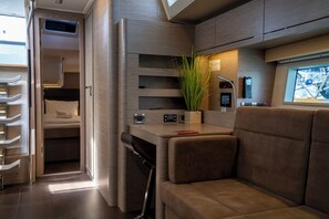 Ein kompaktes, modernes Wohnmobil-Interieur mit einer Küchenzeile, einem Bett und einer Sitzecke.