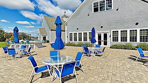 Een gebouw met een ruim terras, meubels en parasols.