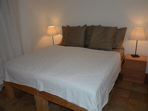 A neatly made bed with a white bedspread and two bedside lamps. - Scapa Appartement/Fewo, Dusche oder Bad, WC 4-Bettwohnung by Interhome (Gstaad)