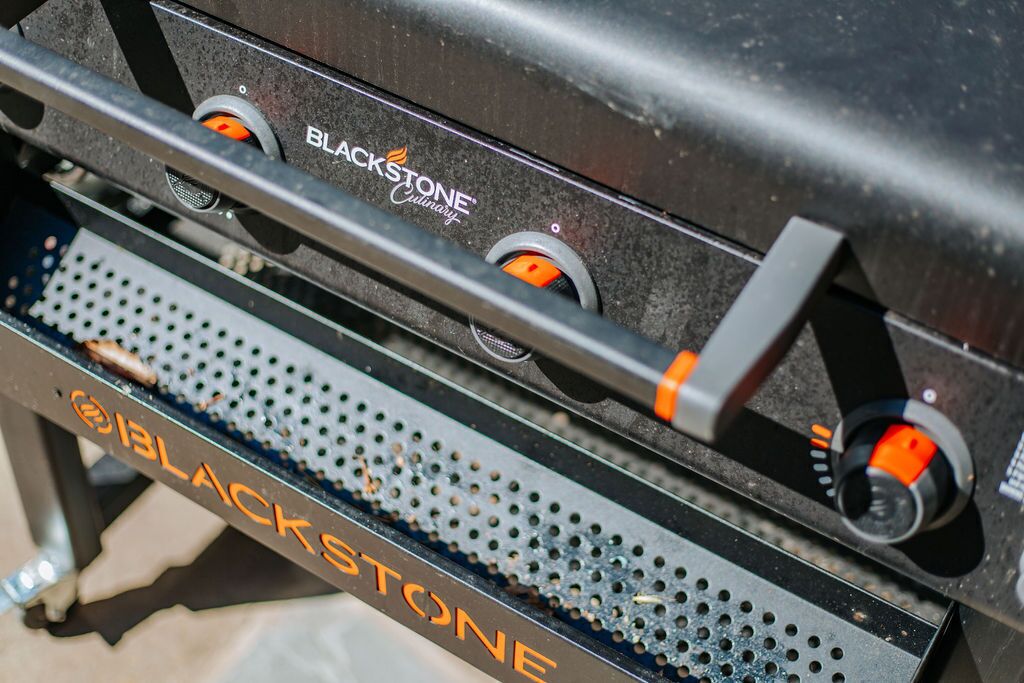 Una parrilla con el logotipo de Blackstone y dos perillas naranjas.
