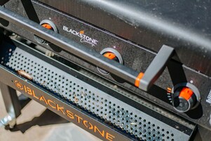 Una parrilla con el logotipo de Blackstone y dos perillas naranjas.