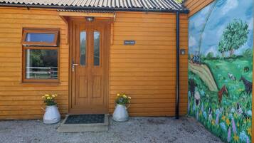 A wooden building with a door, a window, and a sign.
