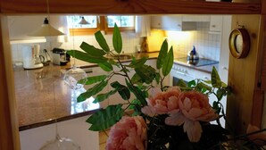 Eine Küche mit einer Holz Arbeitsplatte, einer Kaffeemaschine und einer Vase mit Blumen.