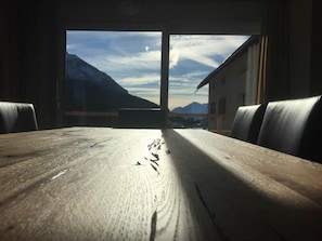 A wooden table with a view of mountains through a window. - Chesa Parpan Appartement/Fewo Appartement/Fewo by Interhome (Valbella)
