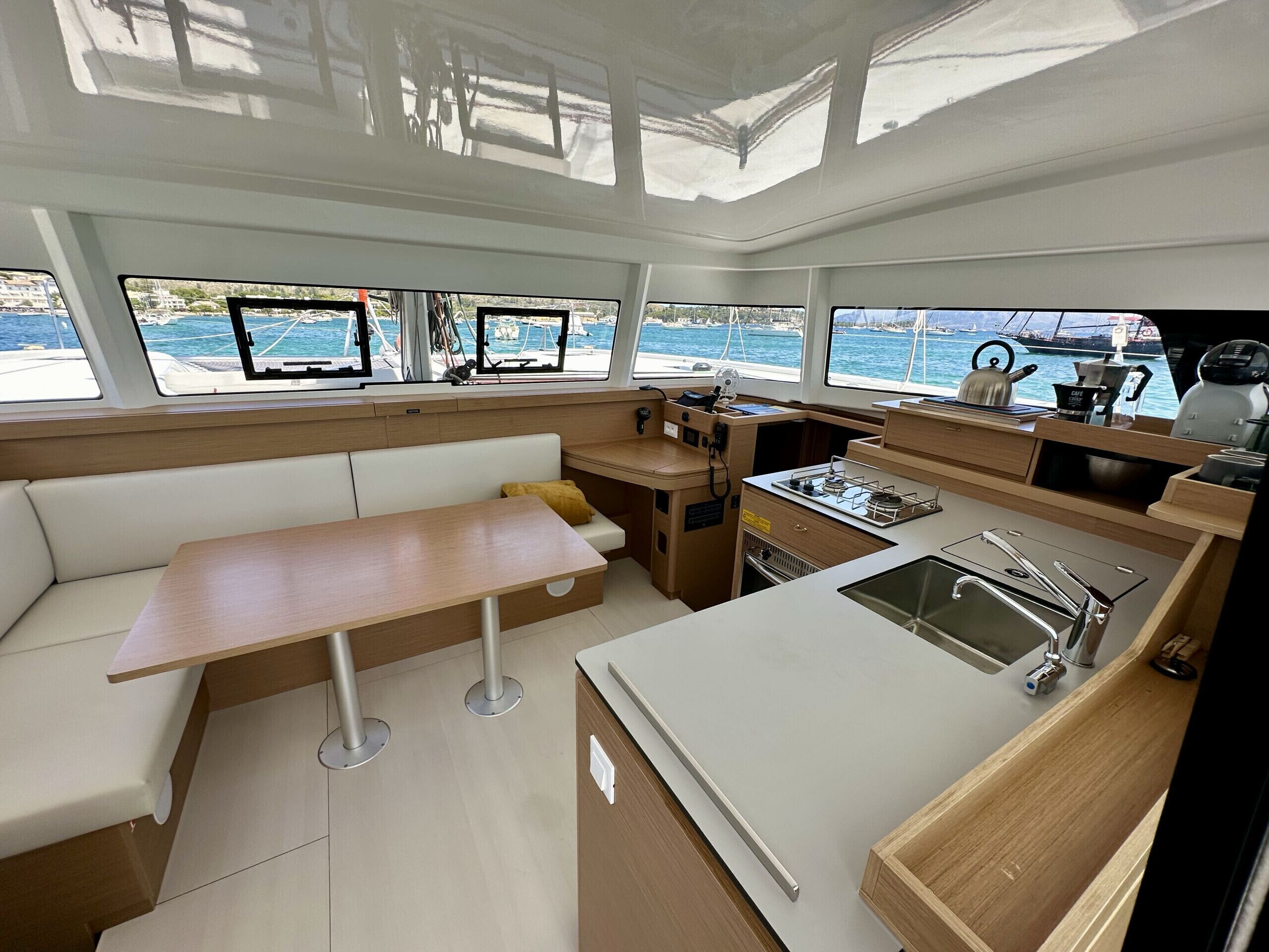 Una pequeña cocina de barco con un fregadero, cocina y zona de estar.