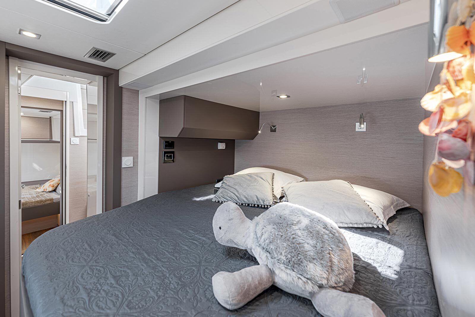 A modern bedroom with a large bed, a built-in wardrobe, and a skylight.