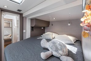 Ein modernes Schlafzimmer mit einem großen Bett, einem eingebauten Kleiderschrank und einem Dachfenster.