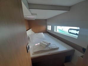 A compact cabin with a single bed, a small window, and a built-in air conditioning unit. - Sun-Kissed Sailing Adventure in the Ionian Islands, Lefkada (Lefkada)