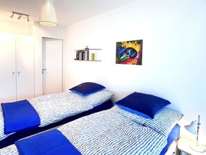A bedroom with two single beds, a bookshelf, a painting, and a lamp. - Pas-Cheus Appartement/Fewo, Bad, WC, 2 Schlafräume by Interhome (Vaz)