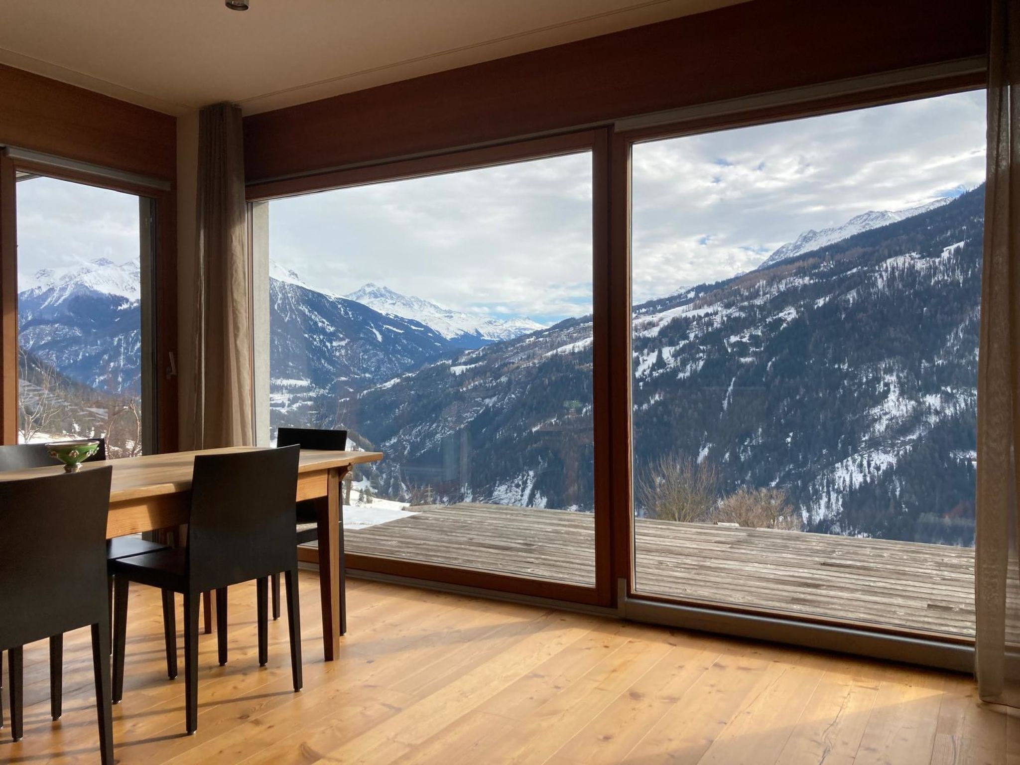 Une chambre moderne dotée de grandes fenêtres offrant une vue sur les montagnes.