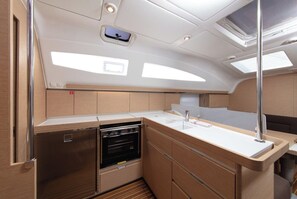 Eine kleine Kombüse mit Edelstahl-Kühlschrank, Backofen und Spüle.