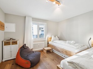 A bedroom with a bed, a small table, a bean bag, and a radiator. - Nr.43 Haus Sotmirana Appartement/Fewo Nr.43 Haus Sotmirana by Interhome (Lenzerheide)