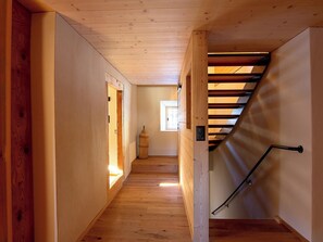 A wooden interior hallway with a staircase leading to a loft area. - Ferienhaus Tgioc Ferienhaus, Dusche und Bad, WC, 4 oder mehr Schlafräume by Interhome (Vaz)