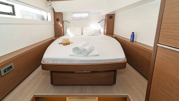 A compact, well-lit bedroom with a bed, a small window, and a fan. - Sun-soaked Sailing Adventure in the Ionian Islands (Perigiali)
