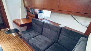 Um espaço interno compacto com sofá, mesa pequena e micro-ondas.