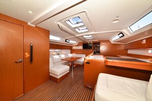 A yacht interior with a dining area, seating, and a kitchen. - Sun-Kissed Sailing Adventure in Zadar, Croatia (Zadar)