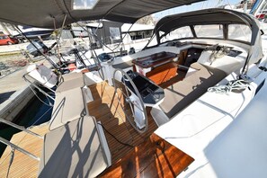 A boat deck with a wooden floor, a steering wheel, and a control panel. - Sun-Kissed Sailing Adventure in Zadar, Croatia (Zadar)