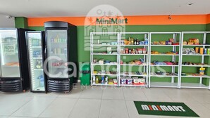 A MiniMart with refrigerated display cases, shelves stocked with various products, and a green floor mat with the MiniMart logo.