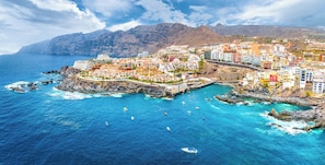 A coastal town with colorful buildings, a bridge, and boats in the water.
