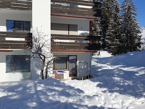 A modern building with multiple balconies, a snow-covered ground, and a tree in front. - Uehlinger Seegarten Wirz Appartement/Fewo,   Wohnung Seegarten Wirz by Interhome (Lenzerheide)