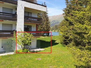 A modern building with a balcony, a small outdoor seating area, and a view of a lake and mountains. - Uehlinger Seegarten Wirz Appartement/Fewo,   Wohnung Seegarten Wirz by Interhome (Lenzerheide)