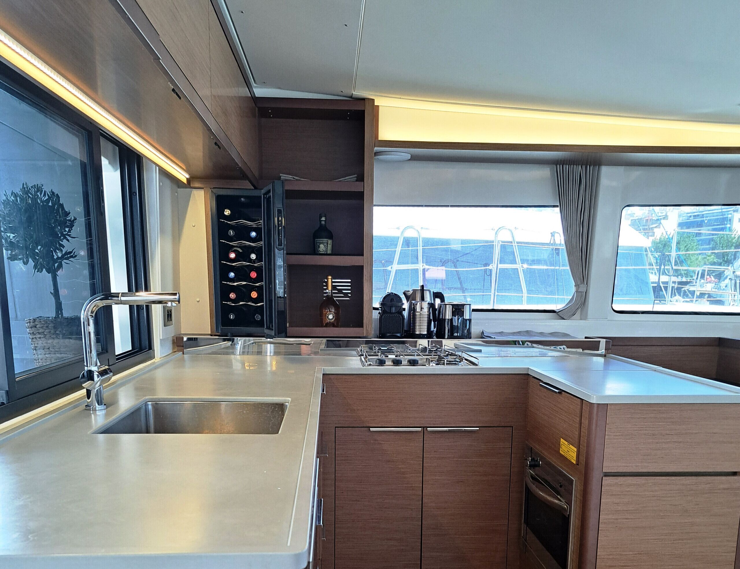 A modern kitchen with stainless steel appliances, wooden cabinets, and a wine cooler.