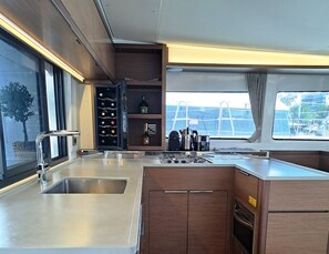 A modern kitchen with stainless steel appliances, wooden cabinets, and a wine cooler.