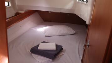 A compact cabin with a single bed, a small table, and a window.