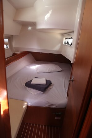 A compact cabin with a single bed, a small table, and a window.