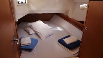 A compact cabin with a bunk bed, a small window, and a toilet.