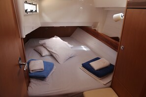 A compact cabin with a bunk bed, a small window, and a toilet. - Sun-Kissed Sailing Adventure in the Stunning Sporades Islands (Loutraki)