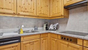 Una cucina con mobili in legno, un piano di lavoro in granito, una lavastoviglie e un fornello.