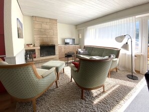 A living room with a fireplace, a television, and seating. - Haus Montana 1/1 Appartement/Fewo,   6-Bettwohnung by Interhome (Lenzerheide)