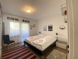 Ein Schlafzimmer mit Bett, Stuhl, Schreibtisch und Nachttisch.