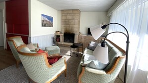 A living room with a fireplace, two armchairs, a sofa, and a table. - Haus Montana 1/1 Appartement/Fewo,   6-Bettwohnung by Interhome (Lenzerheide)