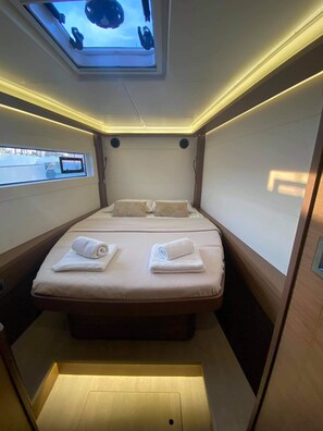 A compact room with a bed, two bedside tables, a skylight, and a window. - Sun-Kissed Sailing Adventure in the Ionian Islands, Lefkada (Lefkada)