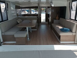 A compact interior with a dining area, seating, and a view through a door. - Sibenik Sun-soaked Sailing: A Luxurious Croatian Voyage (Pirovac)