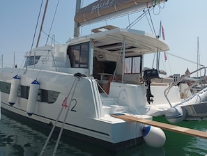 Ein weißes Boot mit der Nummer 42, einem Suzuki Außenborder und einer Kabine mit Dach.
