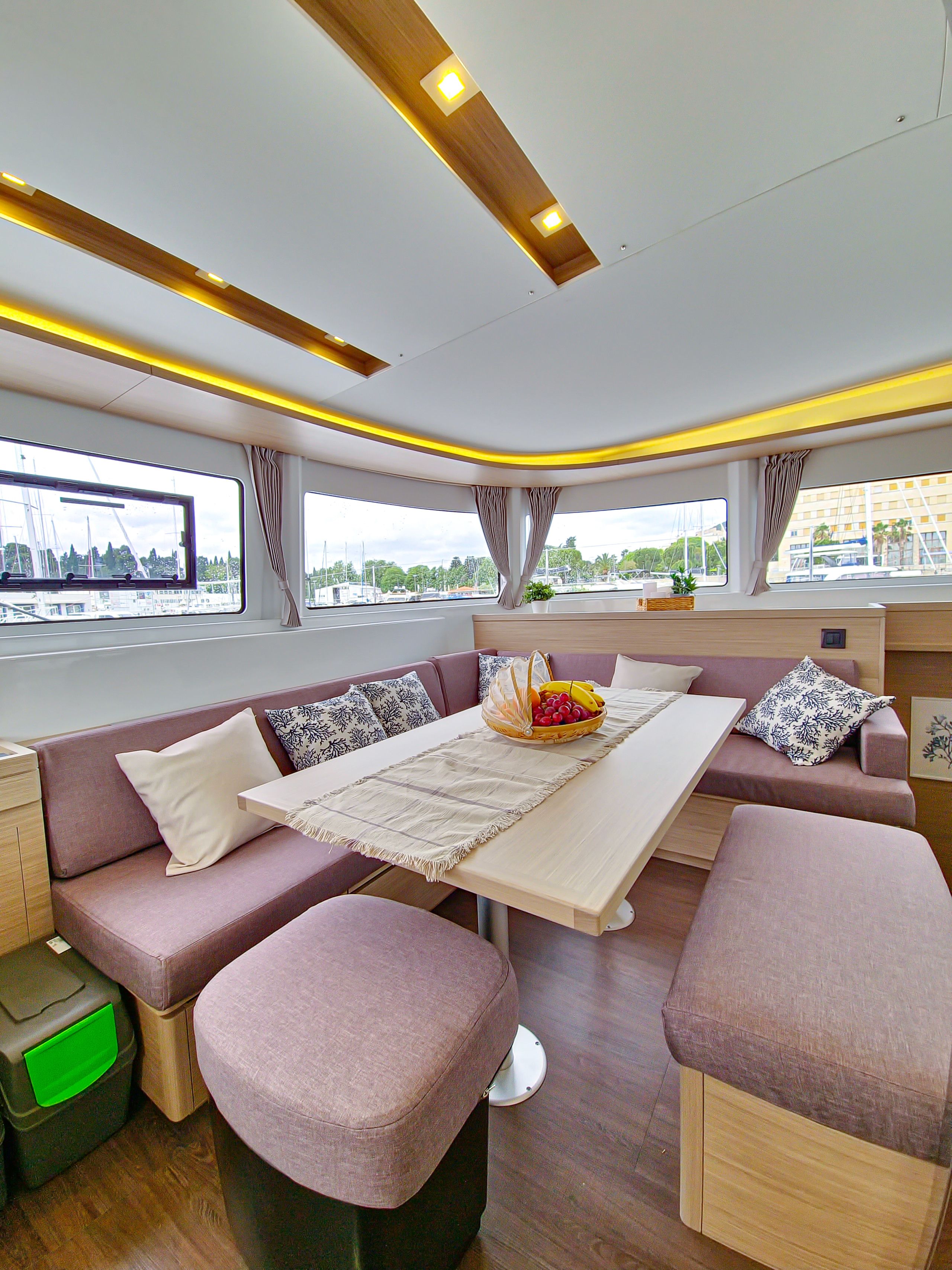 A modern interior with a sofa set, a dining table, and a view through large windows.