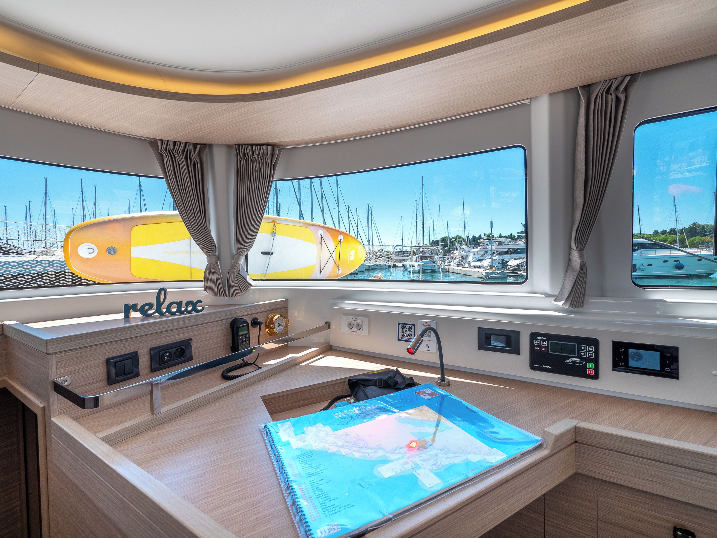 L’intérieur d’un yacht, avec un panneau de commande, une carte et une vue sur le port de plaisance.