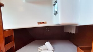 Una cabina compatta con un letto a castello, un piccolo lavandino e un pavimento in legno.