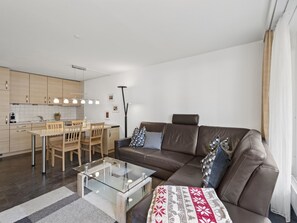 A modern apartment with a dining area, a sofa, and a glass coffee table. - Nr.08 Haus Sursilvana Appartement/Fewo,   Nr.08 Haus Sursilvana by Interhome (Lenzerheide)