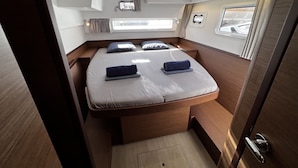 A compact, well-lit cabin with a single bed, a small window, and a skylight. - Sun-Kissed Sailing Adventure in the Majestic Islas Baleares (Ibiza / Eivissa)