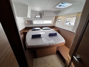 A compact, well-lit cabin with a single bed, a small window, and a skylight. - Sun-Kissed Sailing Adventure in the Majestic Islas Baleares (Ibiza / Eivissa)
