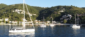 A marina with sailboats, a hillside with buildings, and a clear sky. - Sun-Kissed Sailing Adventure in the Ionian Islands (Kontokali)