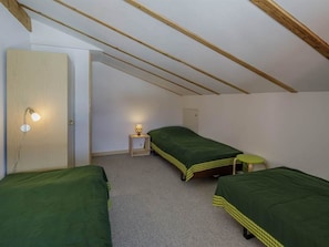 A small, single-room accommodation with two beds, a nightstand, and a wall-mounted light fixture. - Guarda Val Müller Lärchensitz Wohnung Lärchensitz,   Wohnung Lärchensitz by Interhome (Lantsch)