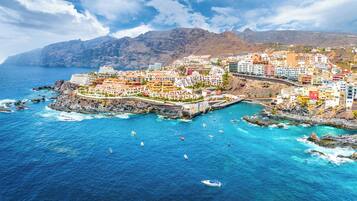 A coastal town with colorful buildings, a bridge, and boats in the water.